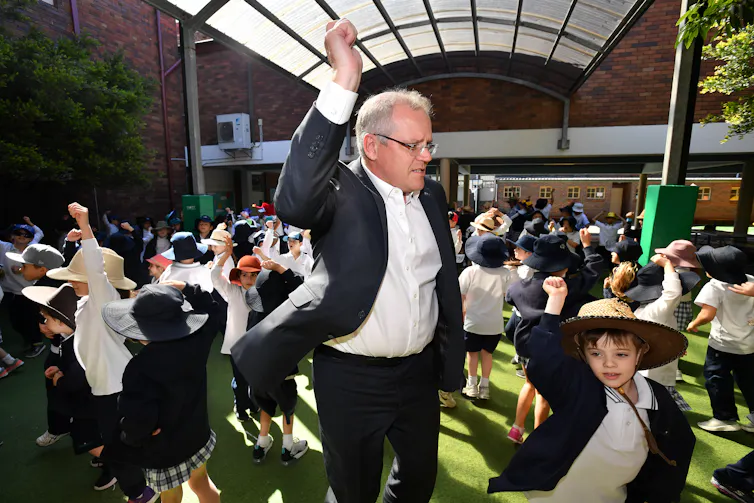 Scott Morrison dances in a crowd of dancing primary school students
