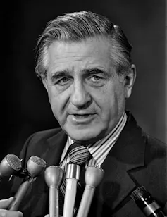 La dinastía Lewis hace un tercer intento de dar forma al socialismo democrático en Canadá 1 Un hombre con espeso cabello gris habla por una serie de micrófonos.