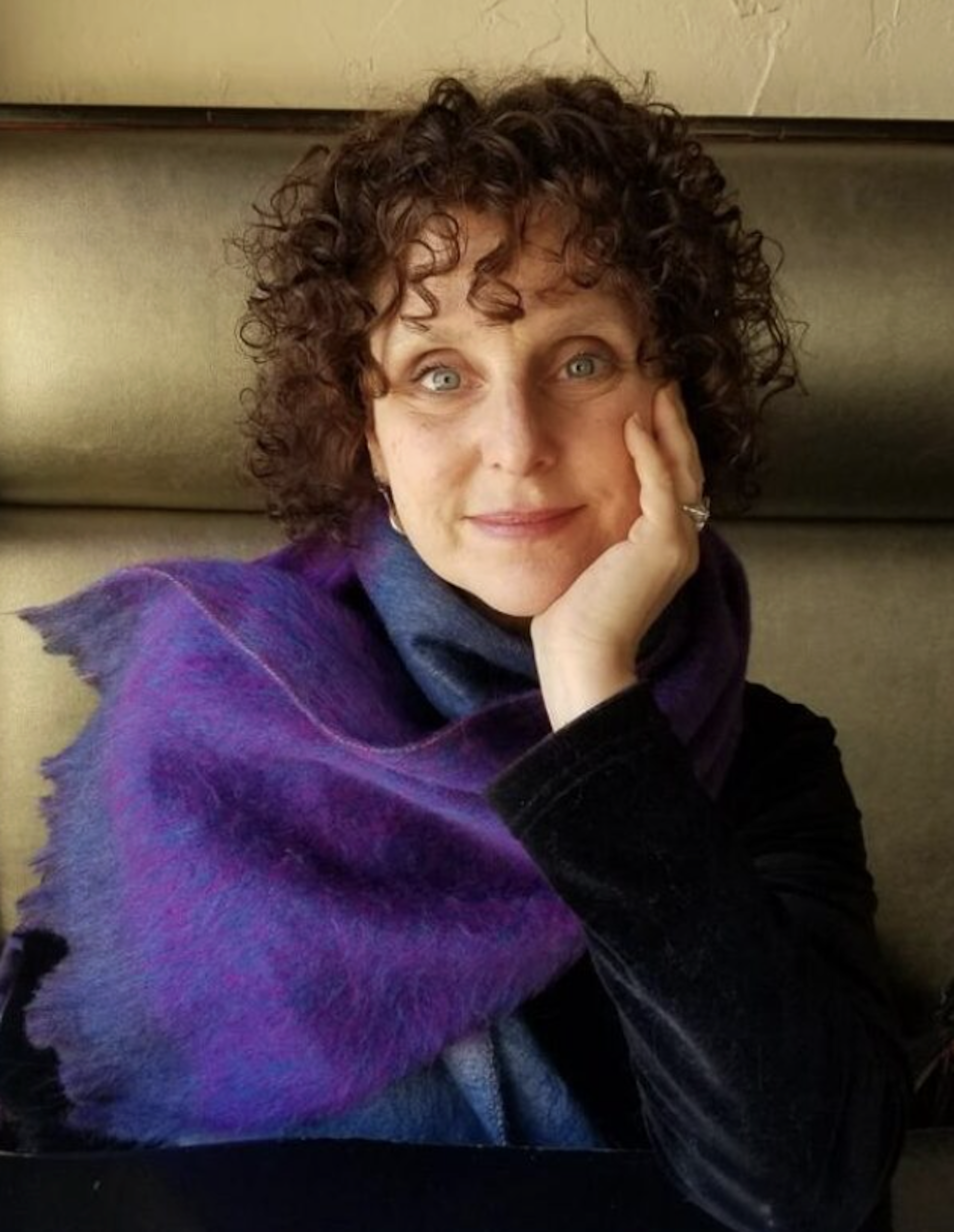 Una mujer de cabello oscuro y rizado.