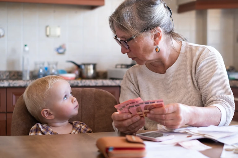 Femme tenant de l'argent à côté d'une petite fille.