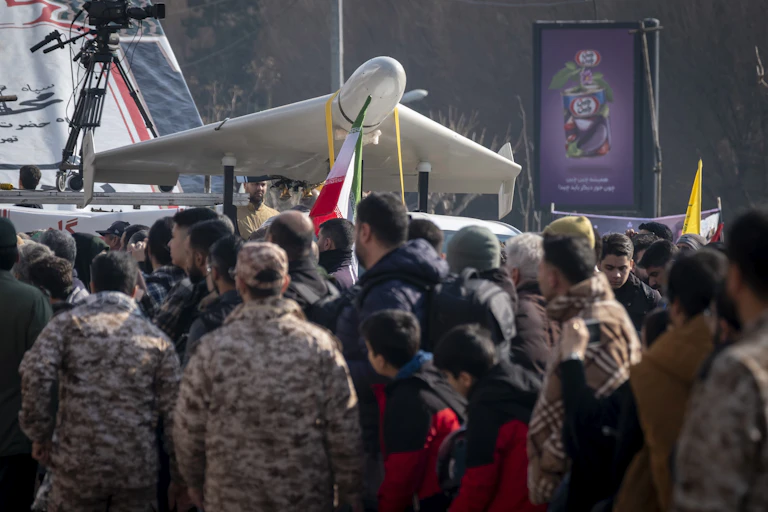 People stand under an unmanned aerial vehicle.