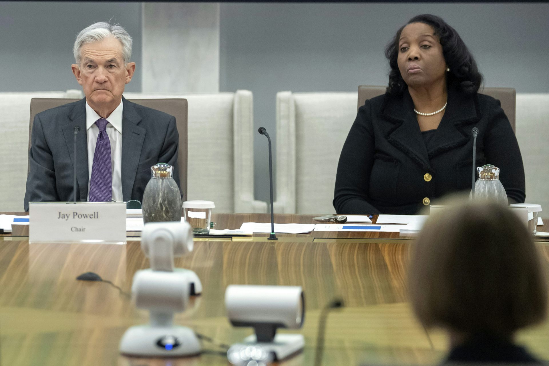 a white man and a Black woman sit at chairs at a table