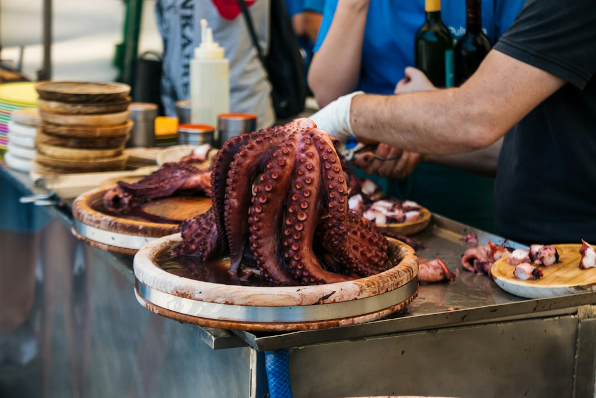 La gente corta los pulpos después de cocinarlos para preparar pulpo a la gallega.