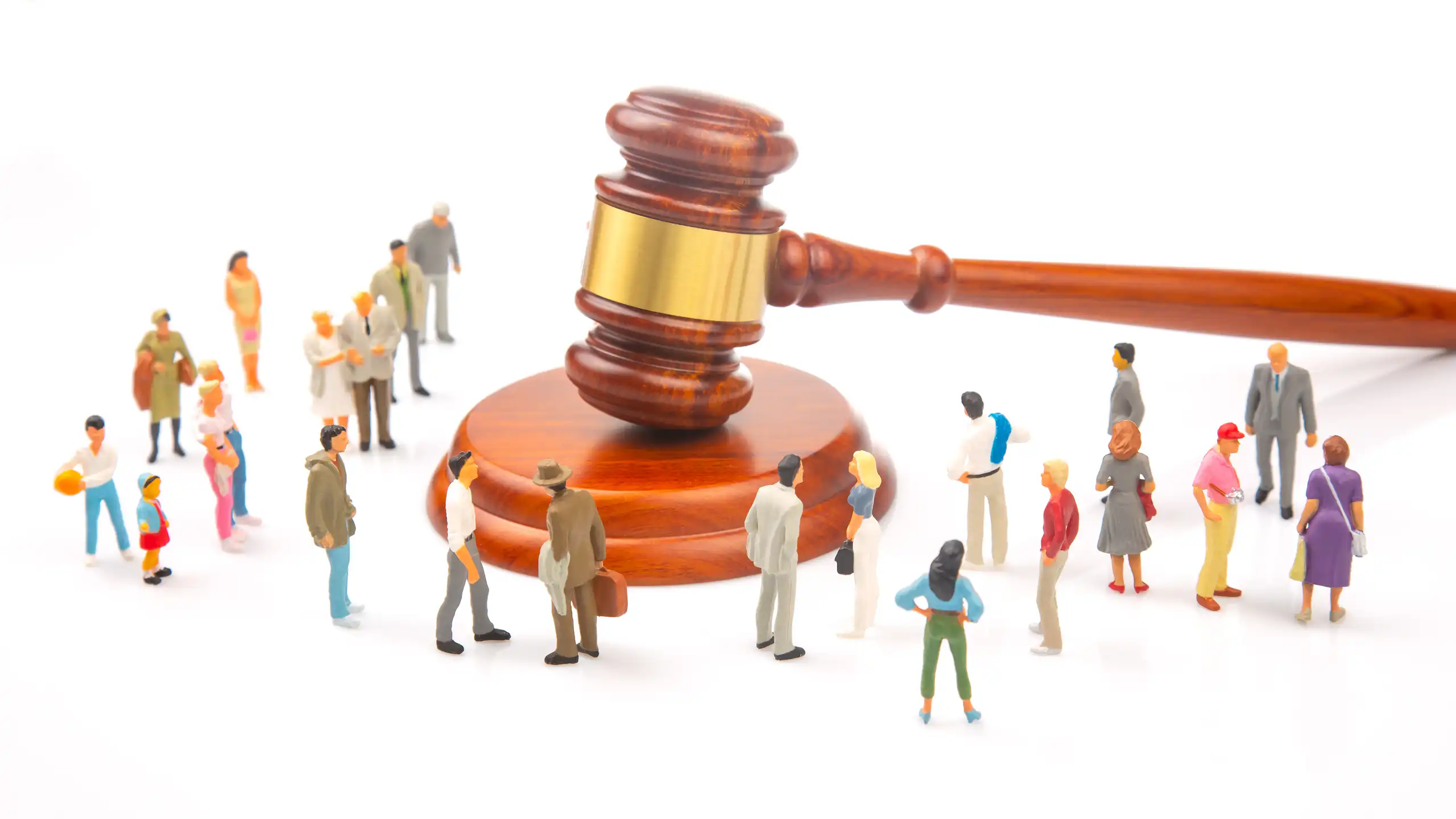 Création : un marteau de justice et des figurines d'êtres humains de taille très inférieure au marteau.