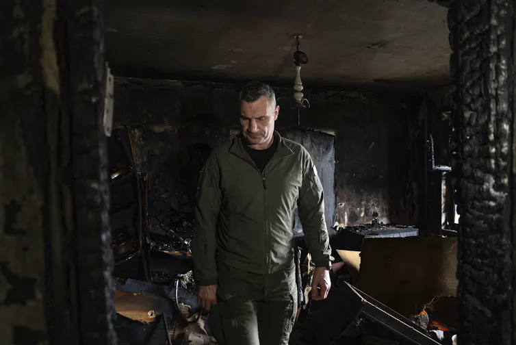 A man walks through a burned out apartment.