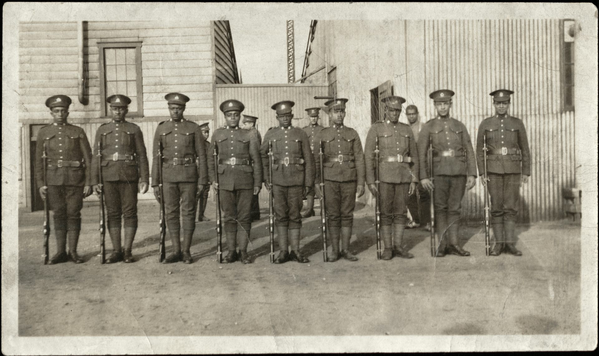 Fotografía en blanco y negro de un grupo de soldados negros uniformados.
