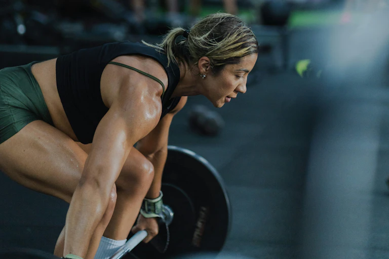 Woman lifting a heavy barbell in a gym