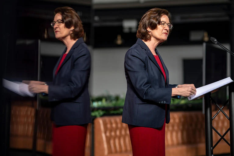 Eluned Morgan stands at a lectern in front of her own reflection.