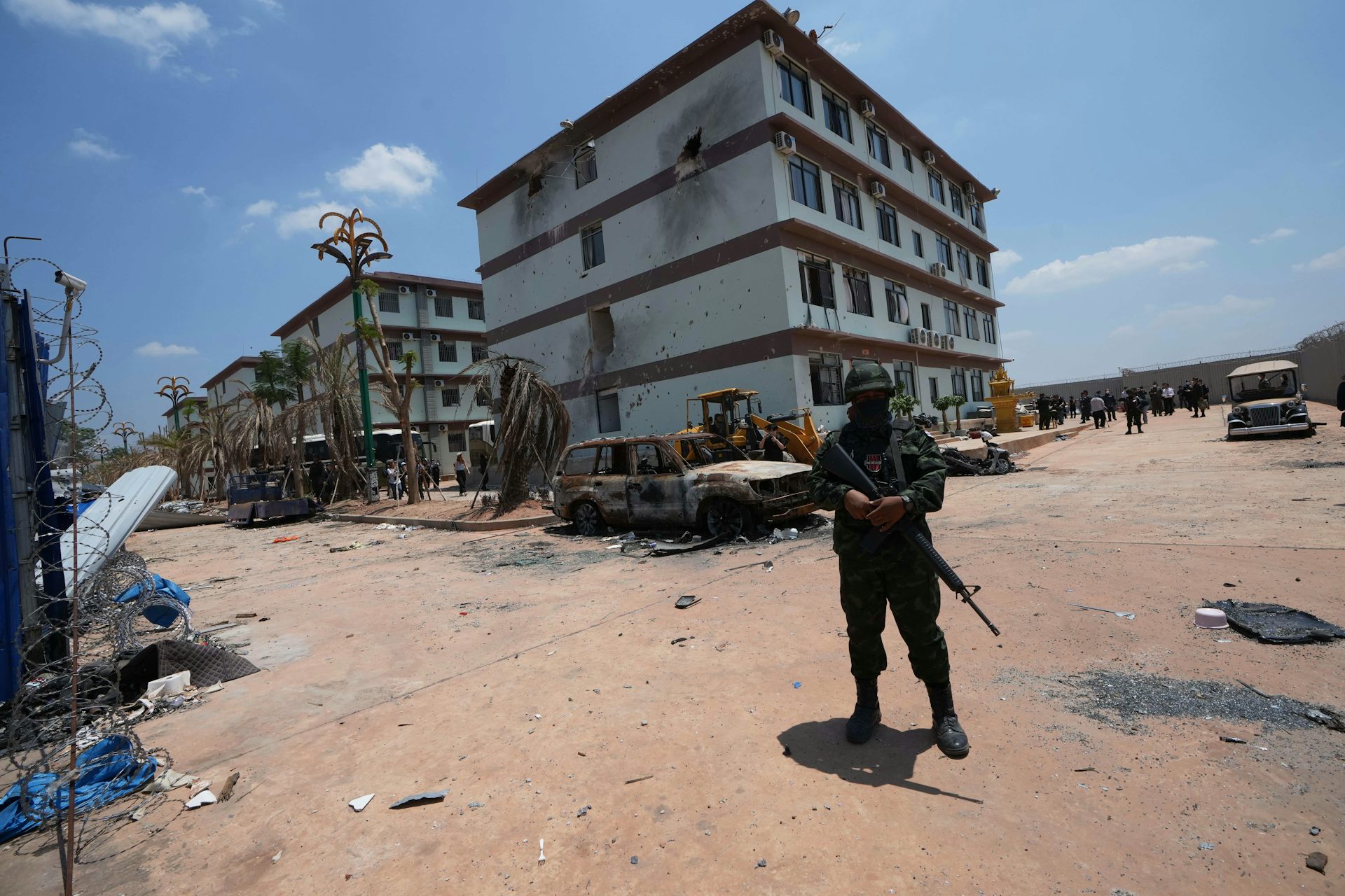 Un soldat armé se tient devant un bâtiment.