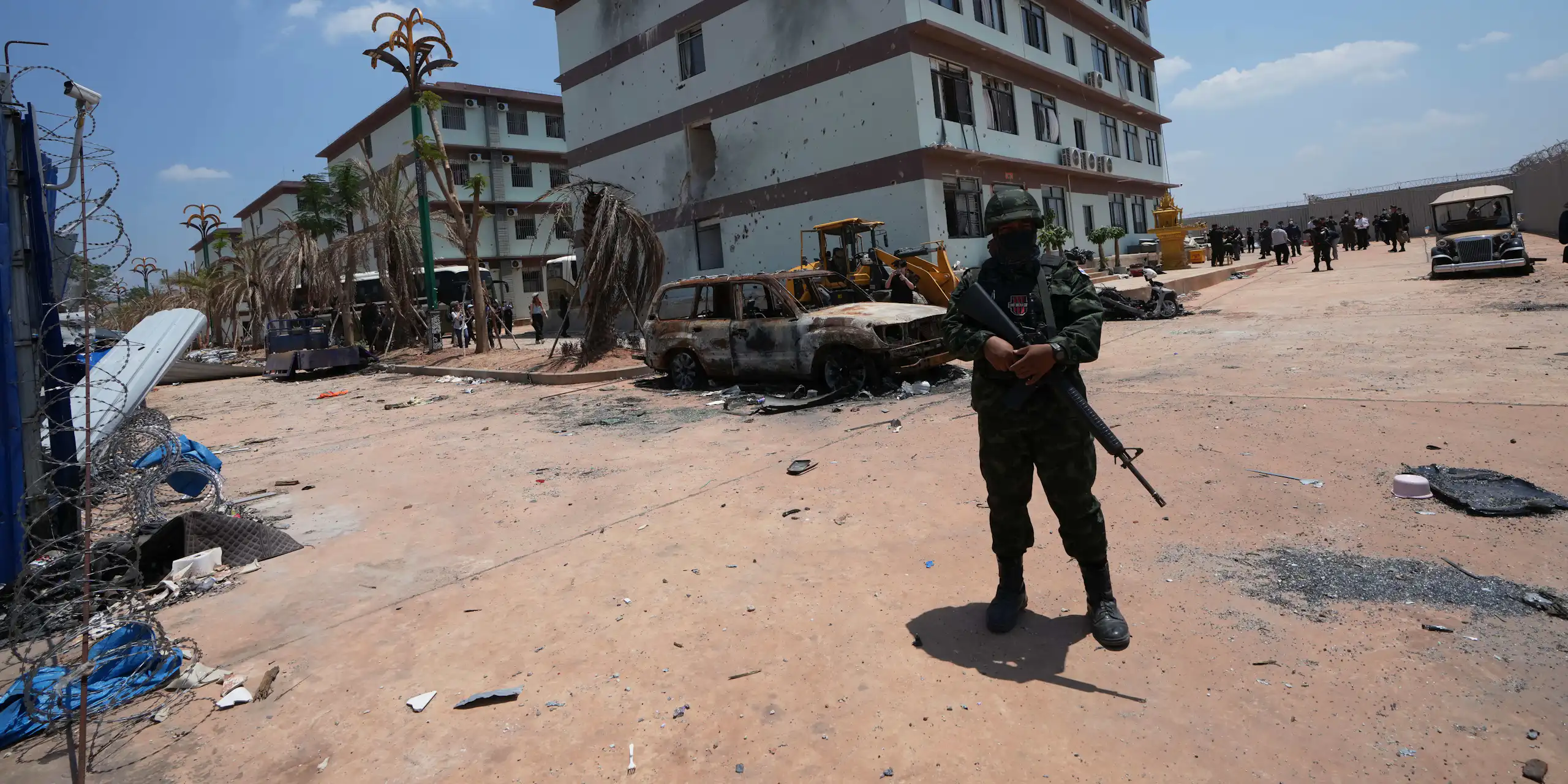 Un soldat armé se tient devant un bâtiment.