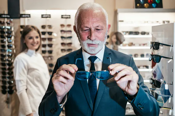 an older man holds a pair of sunglasses