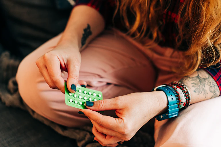 Woman holding a contraceptive pill blister pack.
