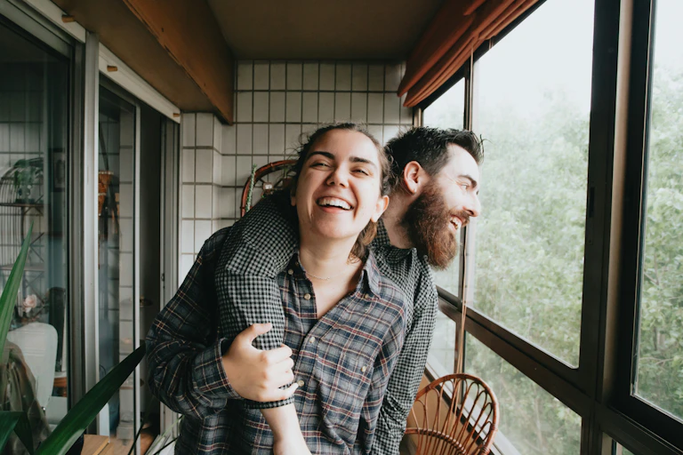 Man and woman laughing and hugging.