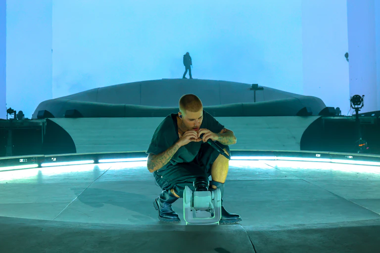 Bieber di atas panggung, membuat bentuk hati dengan kedua tangannya ke arah kamera.