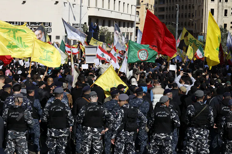 Hezbollah supporters carry their party's flags during a protest in Beirut.