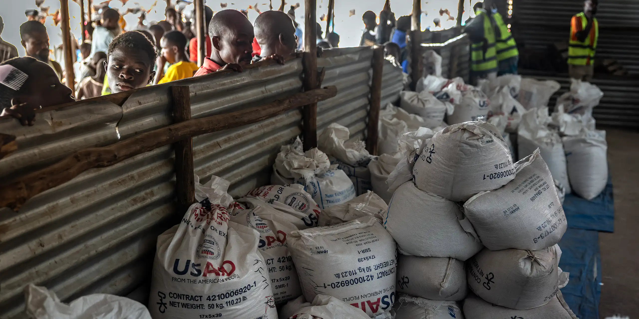 Des réfugiés congolais devant les derniers lots de vivres livrés par l’Agence des États-Unis pour le développement international (USAID), désormais démantelée, dans une zone de stockage et de distribution alimentaire du camp de réfugiés de Musenyi, à Giharo, le 7 mai 2025. Dans des camps surpeuplés installés dans l’un des pays les plus pauvres du monde, l’aggravation de la crise financière menace l’aide humanitaire essentielle, notamment l’aide alimentaire qui a été considérablement réduite, ce qui fait craindre une recrudescence de la violence.