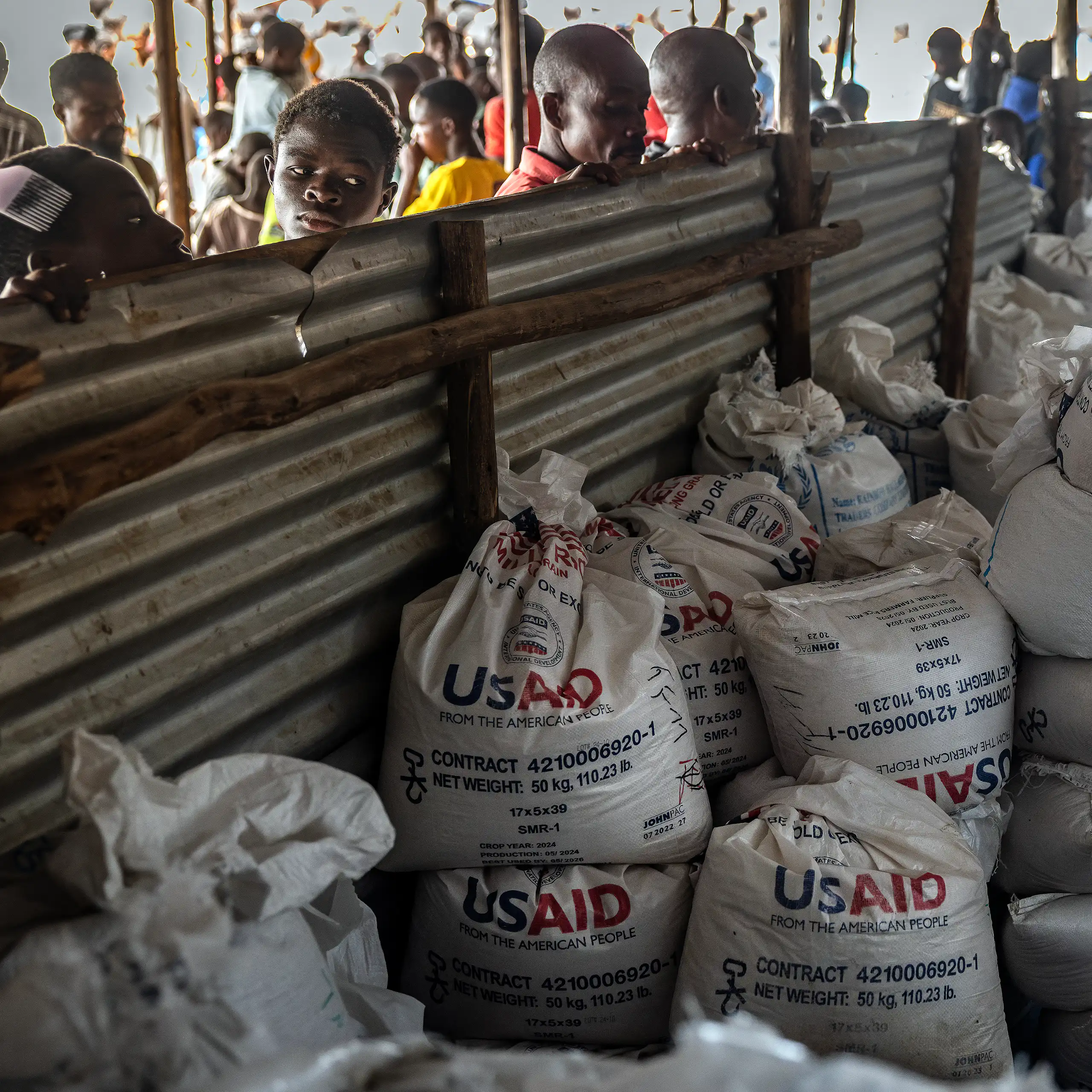 Des réfugiés congolais devant les derniers lots de vivres livrés par l’Agence des États-Unis pour le développement international (USAID), désormais démantelée, dans une zone de stockage et de distribution alimentaire du camp de réfugiés de Musenyi, à Giharo, le 7 mai 2025. Dans des camps surpeuplés installés dans l’un des pays les plus pauvres du monde, l’aggravation de la crise financière menace l’aide humanitaire essentielle, notamment l’aide alimentaire qui a été considérablement réduite, ce qui fait craindre une recrudescence de la violence.
