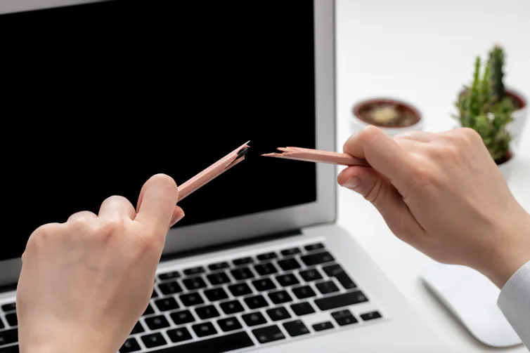 a make worker snaps a pencil over his laptop