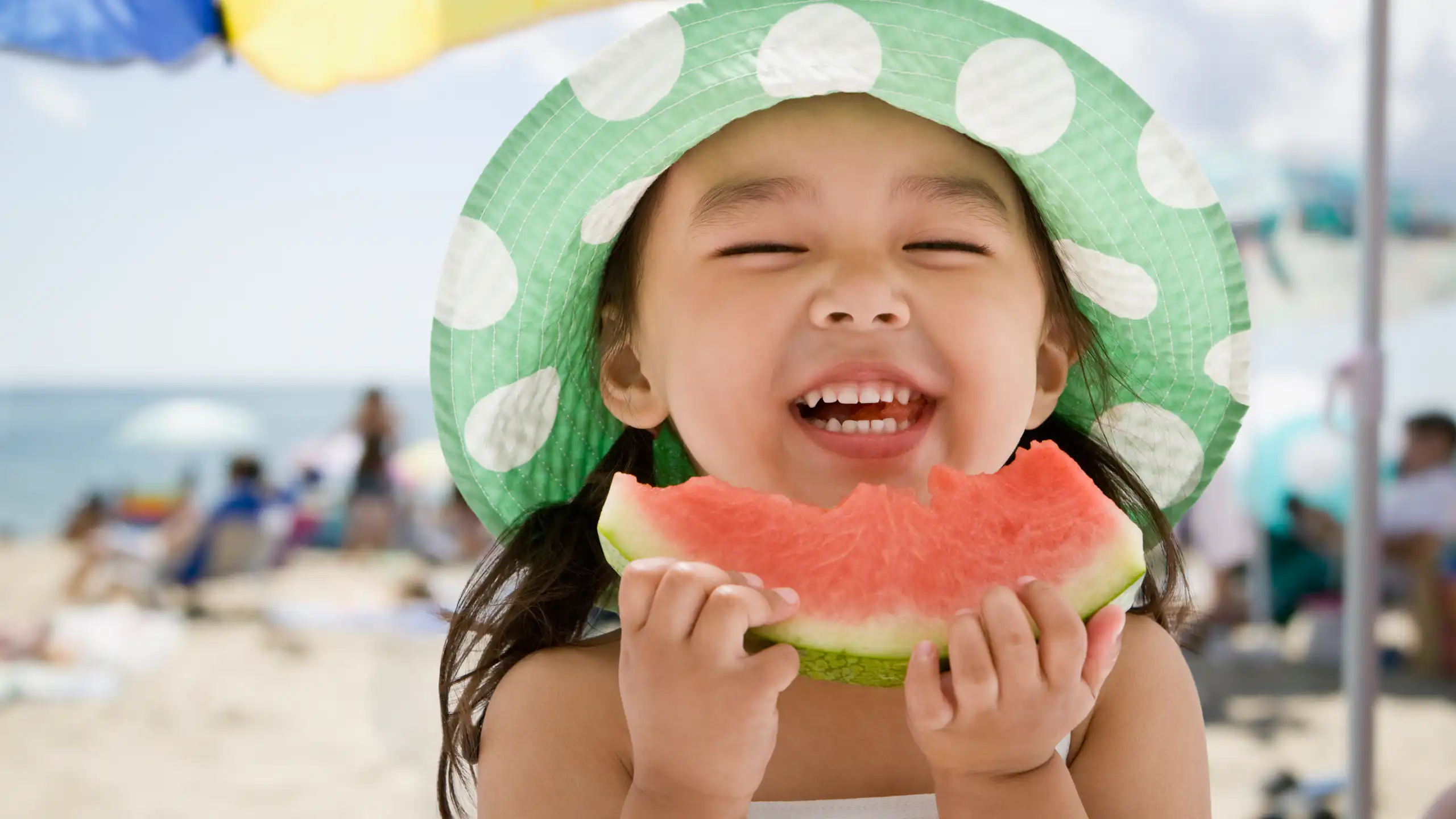 Smiling little girl eating watermelon.