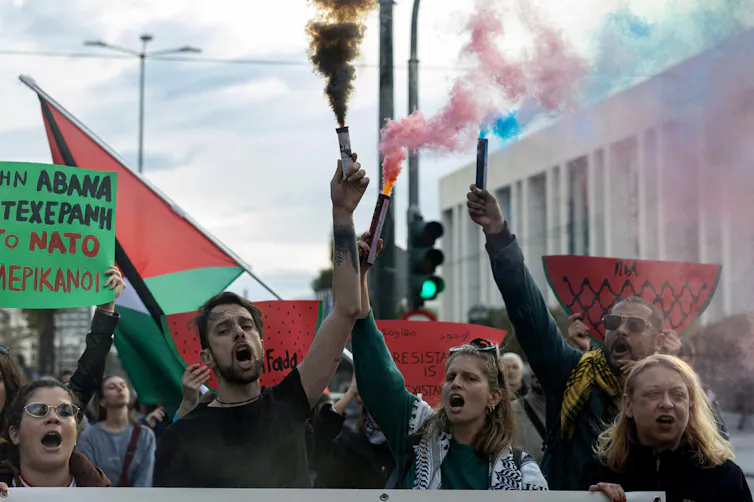 Protesters At a rally as one holds a flare.