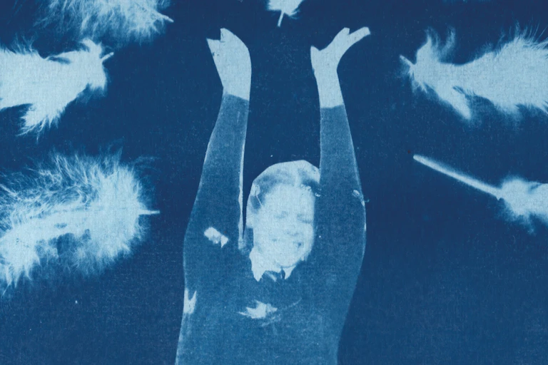 Image of a woman jumping surrounded by giant feathers