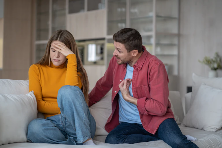 A man arguing with a woman. She is not engaging and faces away from him.