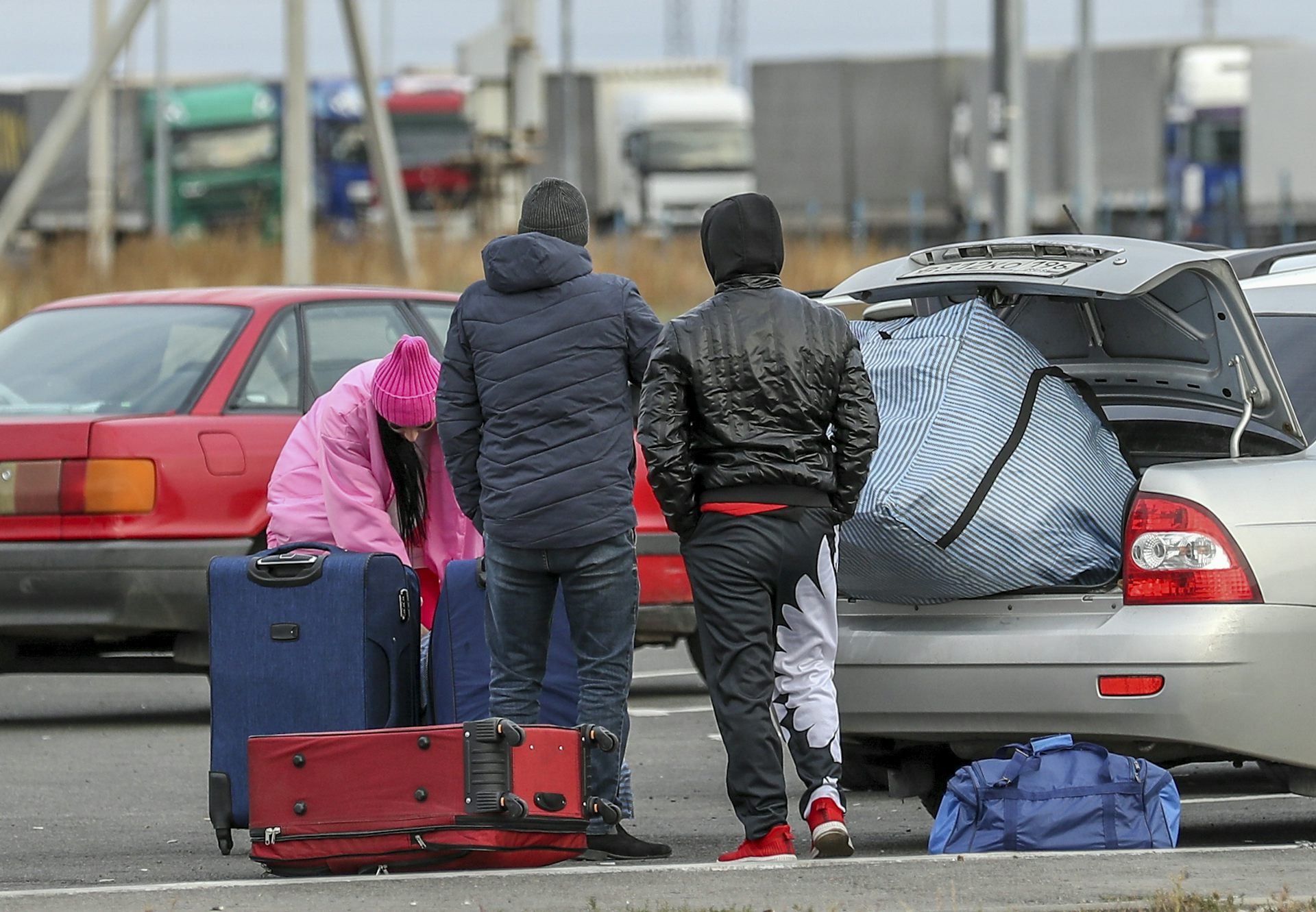 Three Russians handle their luggage at the Russia-Kazakhstan border.