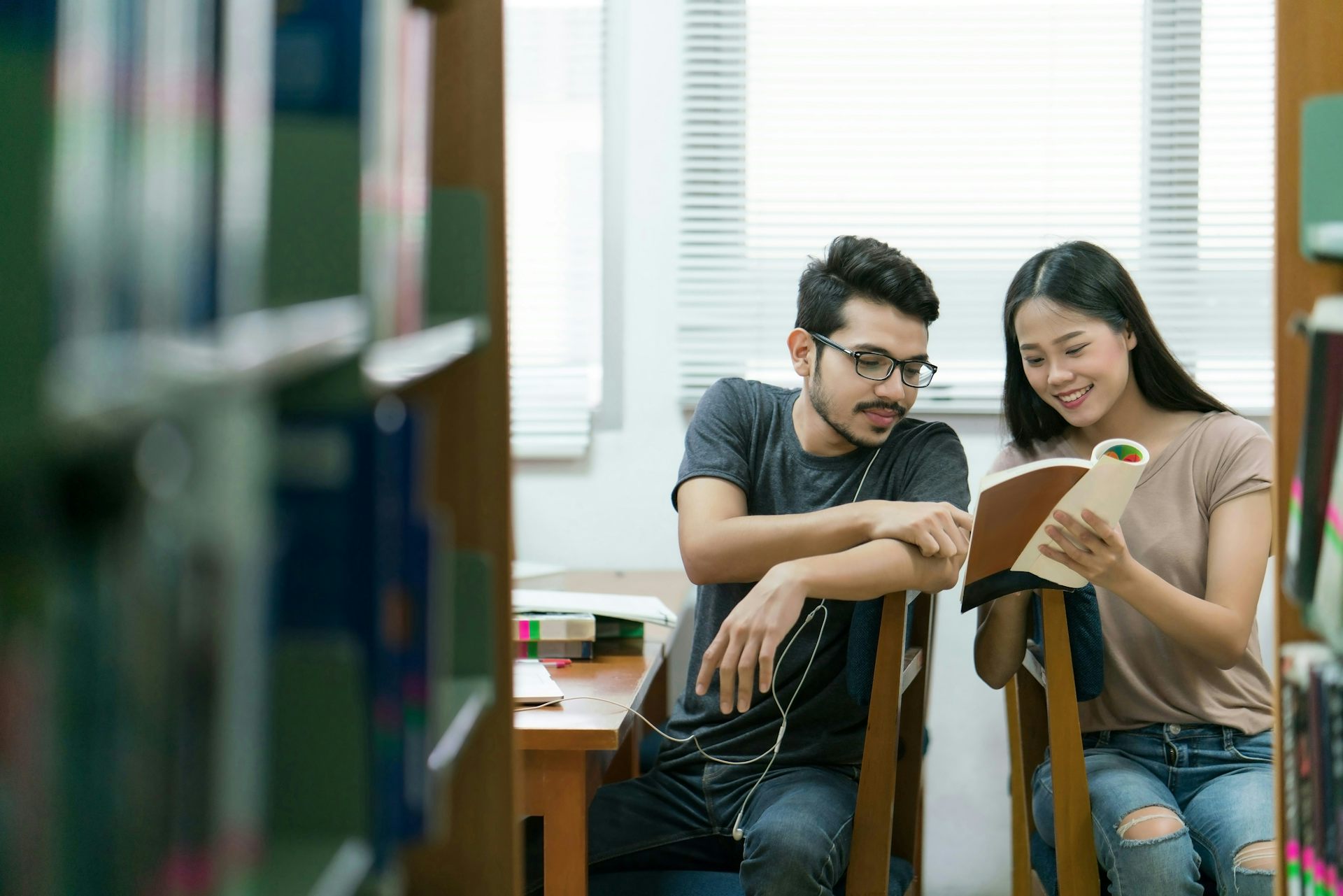 Dos estudiantes vistos hablando en la biblioteca.