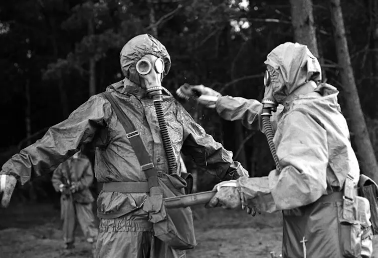 Two mena are seen in hazmat suits.