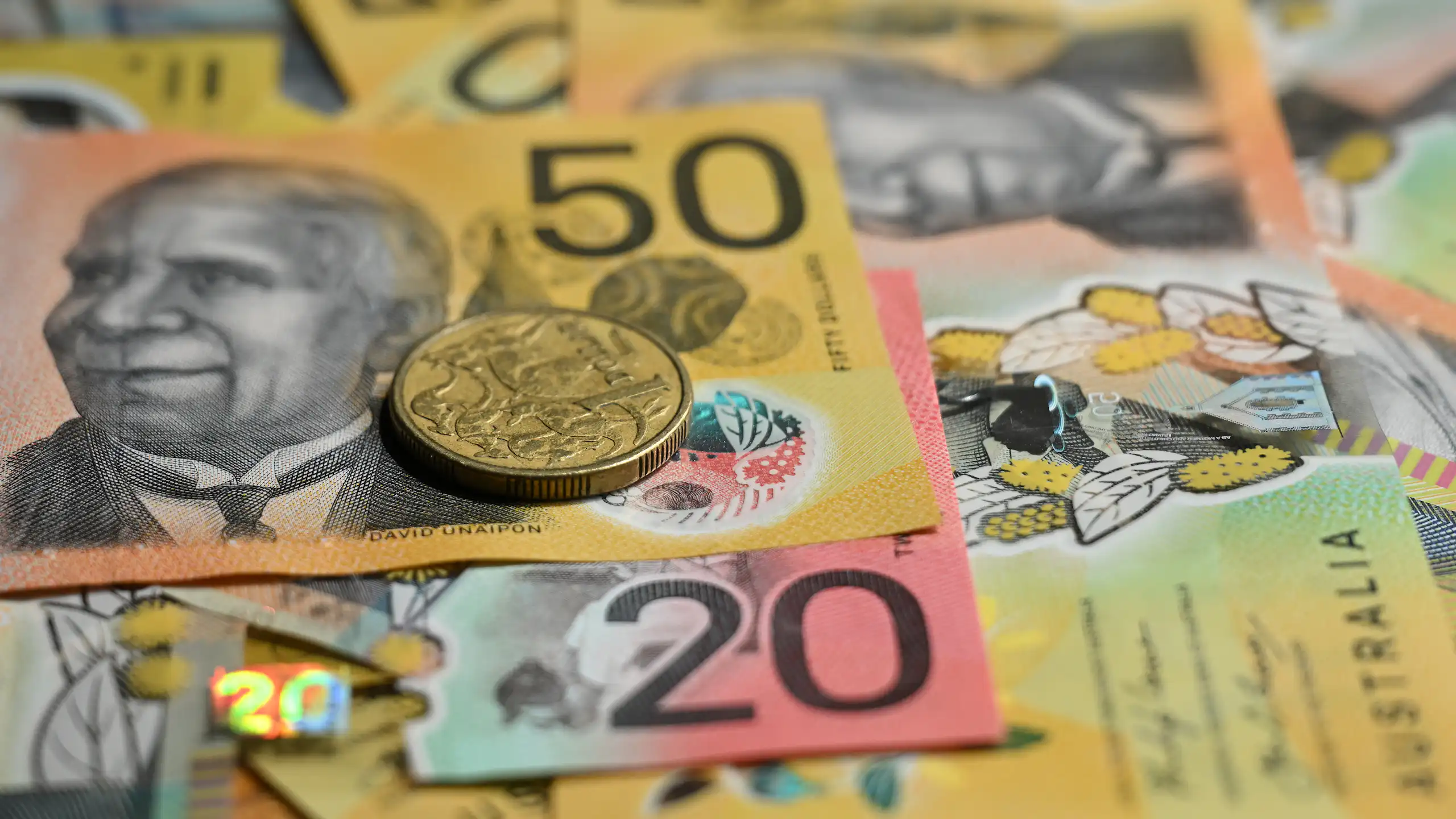 Generic images of Australian fifty and twenty dollar notes and a dollar coin