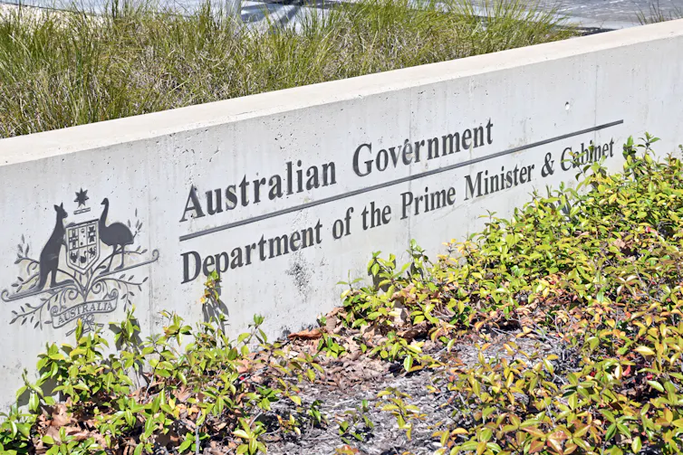 A concrete sign with the Australian coat of arms saying department of prime minister and cabinet