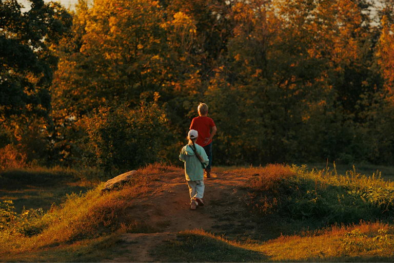 Children walk outside at dusk.