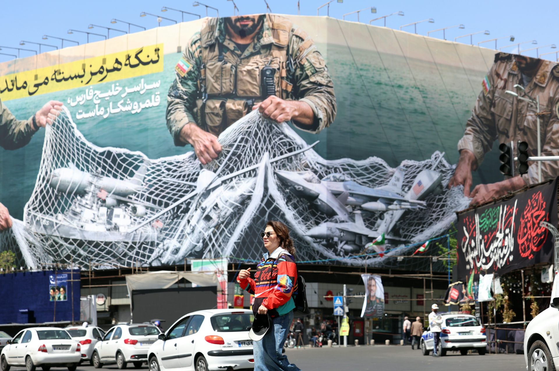 A poster in Tehran shows Iranian fighters holding a net over the Strait of Hormuz reading 'The Strait of Hormuz remains closed'