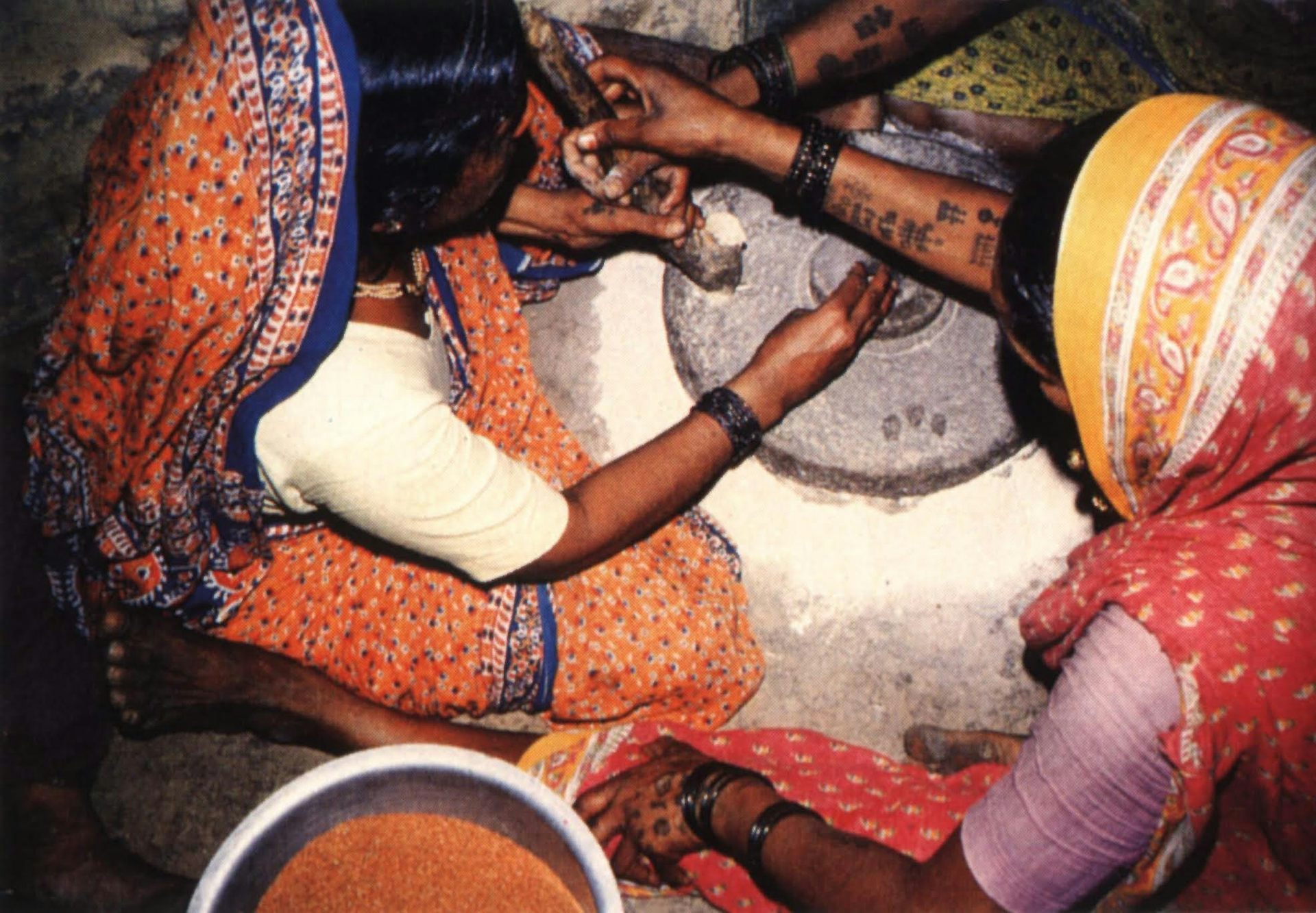 Women working at the grindstone in rural India.