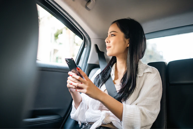 young smiling woman sitting in the back of a taxi
