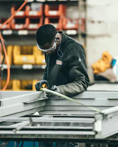 Un employé de la construction travaille en portant des bouchons d’oreilles
