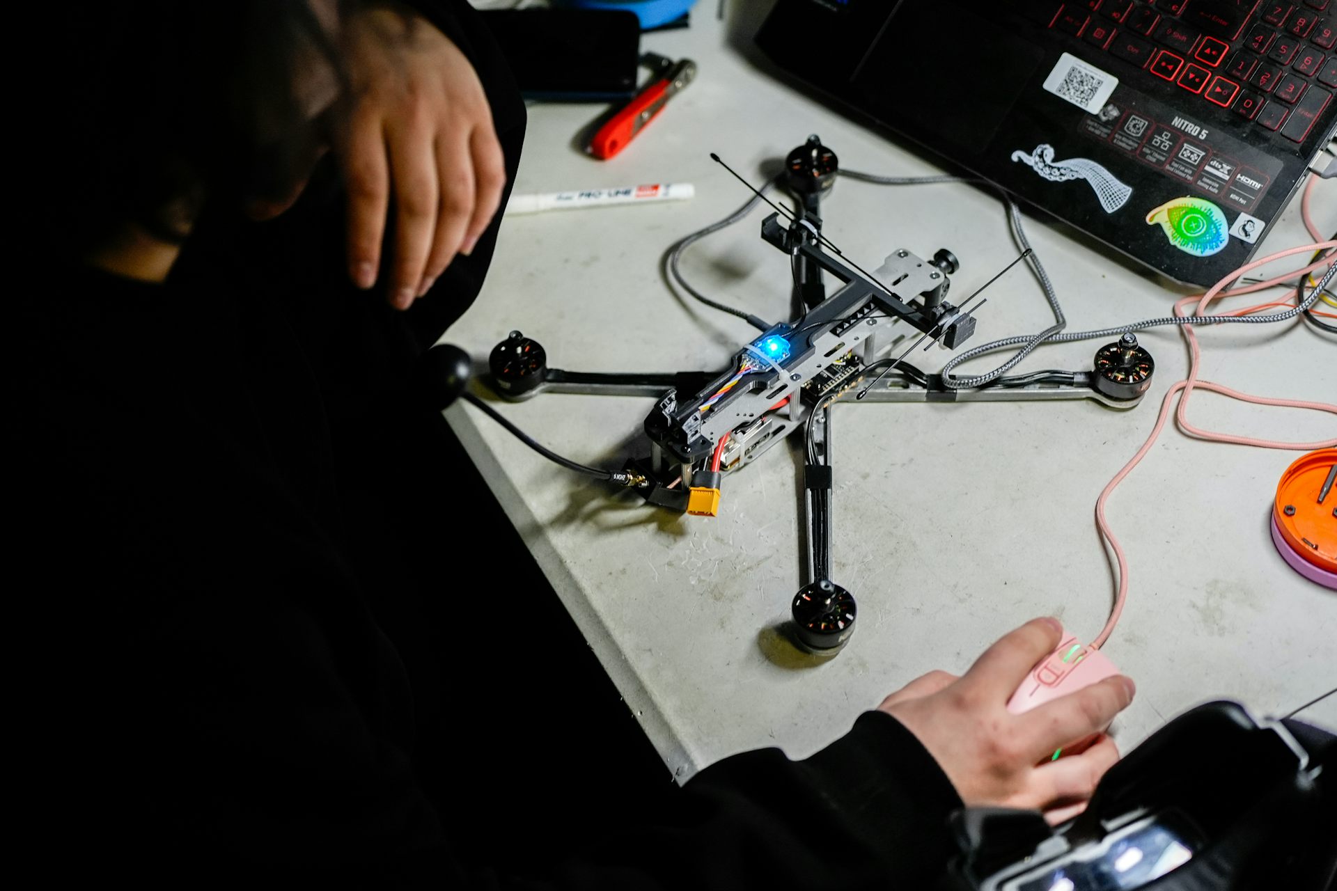 Drone sobre la mesa; a ambos lados se pueden ver manos de hombres.