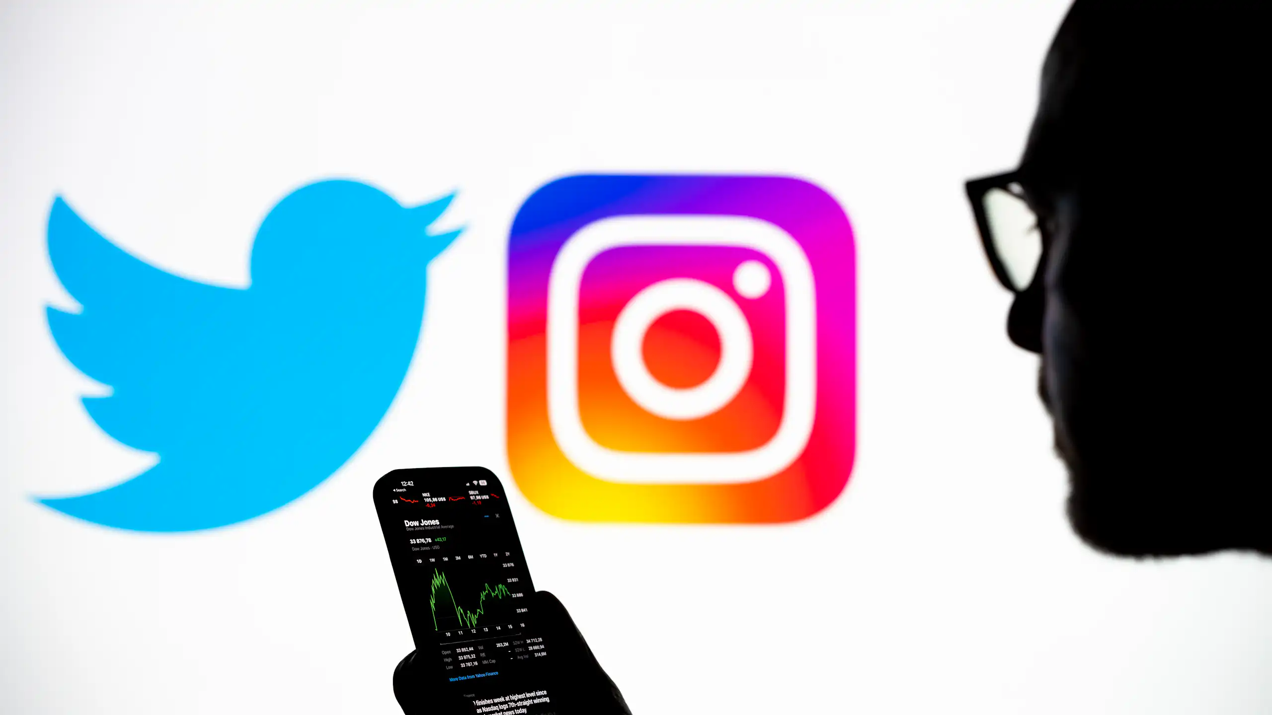 An illustration photo displays the Twitter and Instagram logos as well as a silhouetted image of a person holding a smart phone.