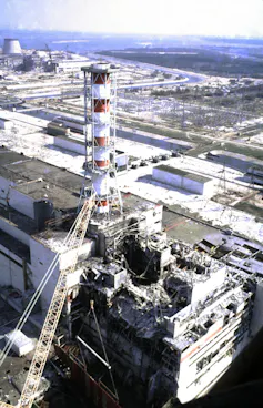 Image shows rubble next to a red and white chimney