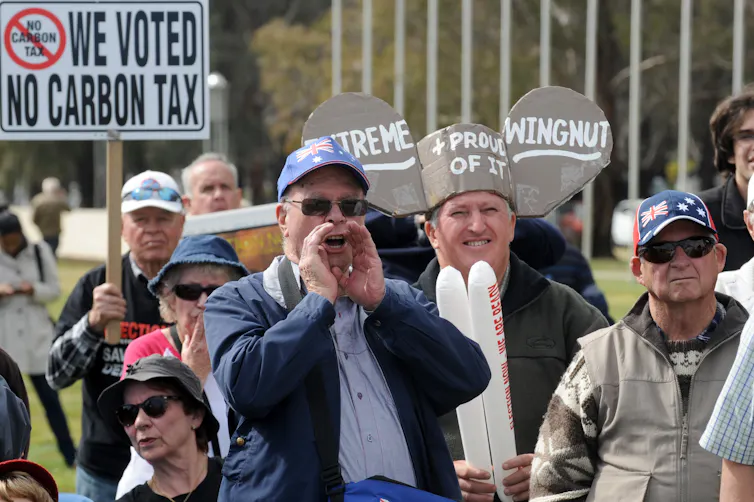 A group of protesters hold a sign that says we voted no carbon tax