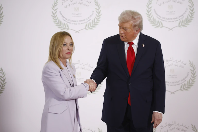 Giorgia Meloni and Donald Trump shake hands.