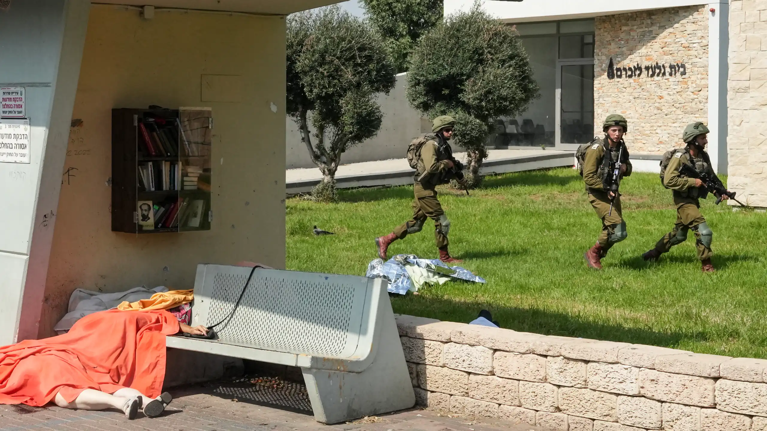 Des soldats israéliens sécurisent une zone où gisent, recouverts d'une bâche, les corps de civils tués lors d'une attaque menée par des militants palestiniens, dans la ville de Sderot, au sud d'Israël, le 7 octobre 2023.