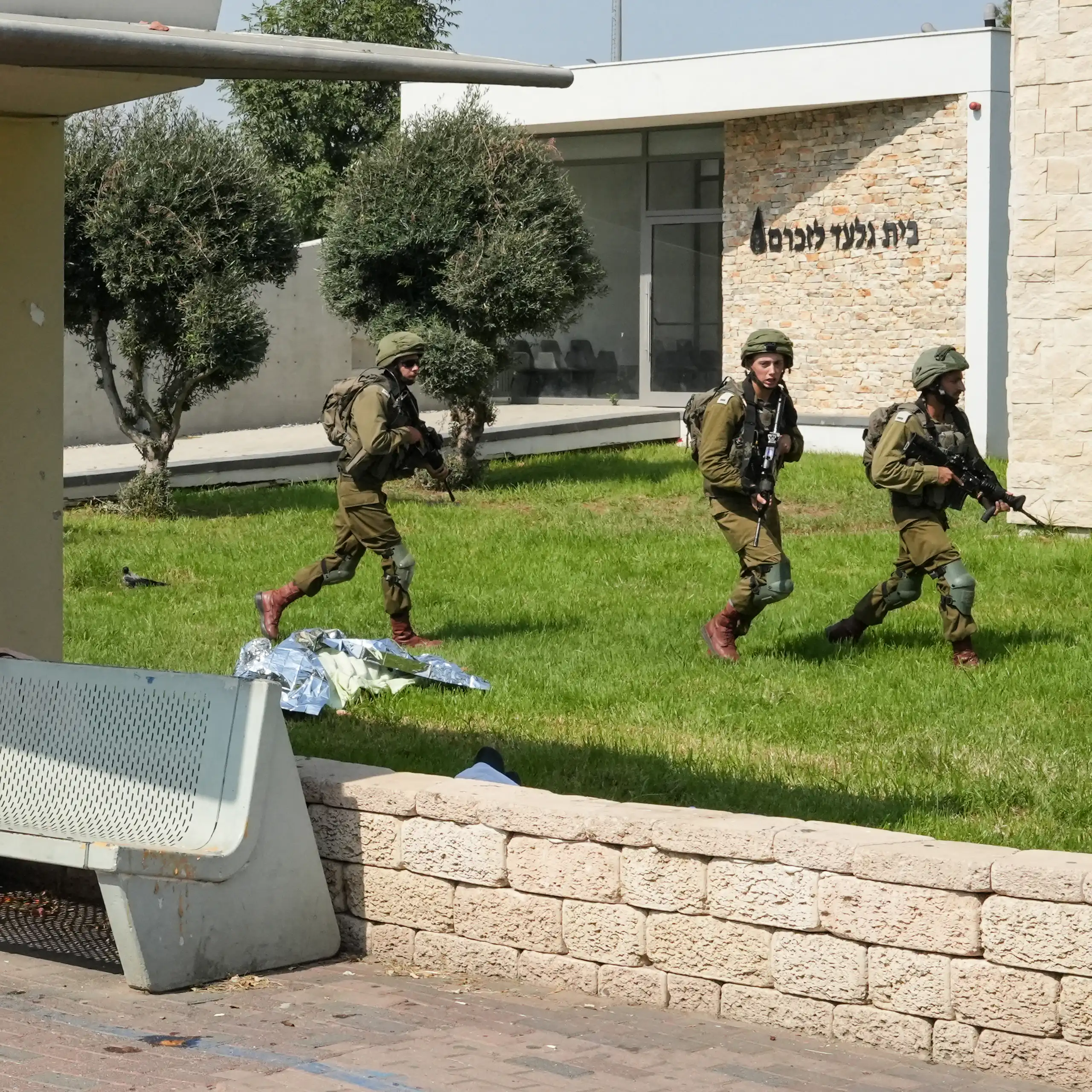 Des soldats israéliens sécurisent une zone où gisent, recouverts d'une bâche, les corps de civils tués lors d'une attaque menée par des militants palestiniens, dans la ville de Sderot, au sud d'Israël, le 7 octobre 2023.