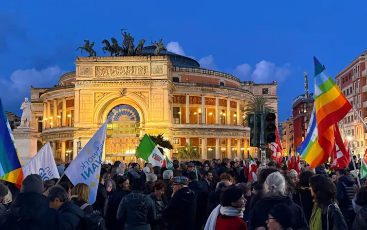 Italians wave flags as they celebrate in the streets of Palermo.