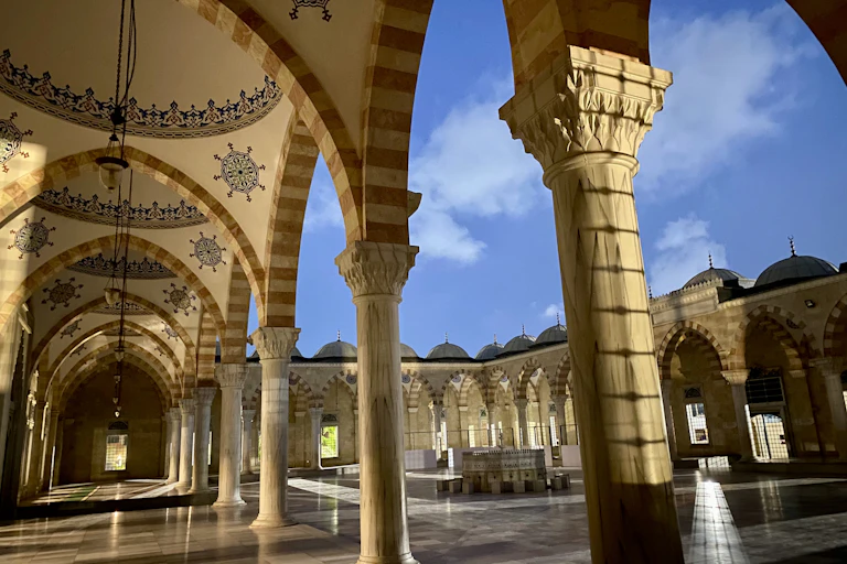 Large building with domes, pillars and paved courtyard