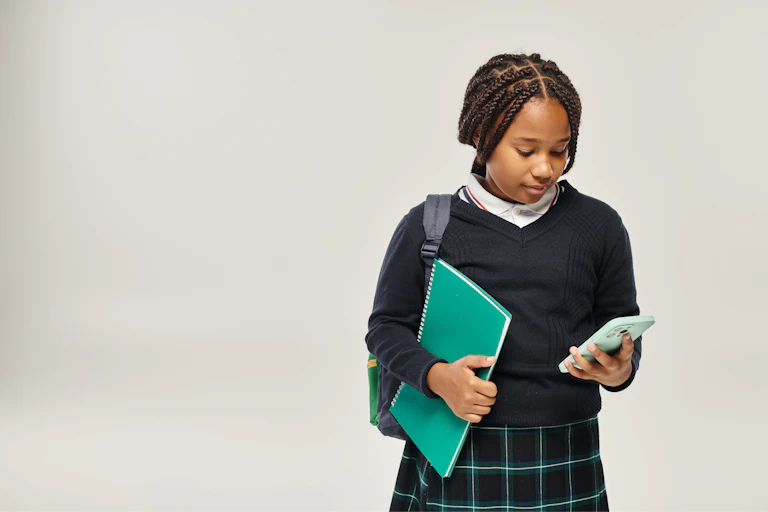 Girl in uniform looking at mobile phone