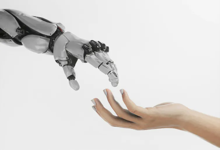A robotic hand and a human one almost touch.
