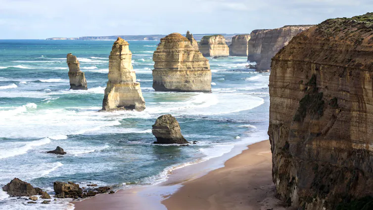 Photo of rocky pillars and cliffs rising from the sea.