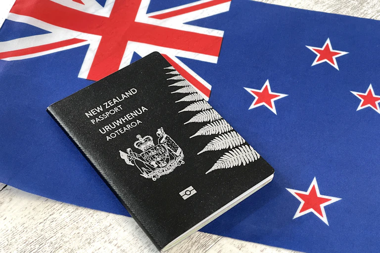 New Zealand passport lying on top of a New Zealand flag