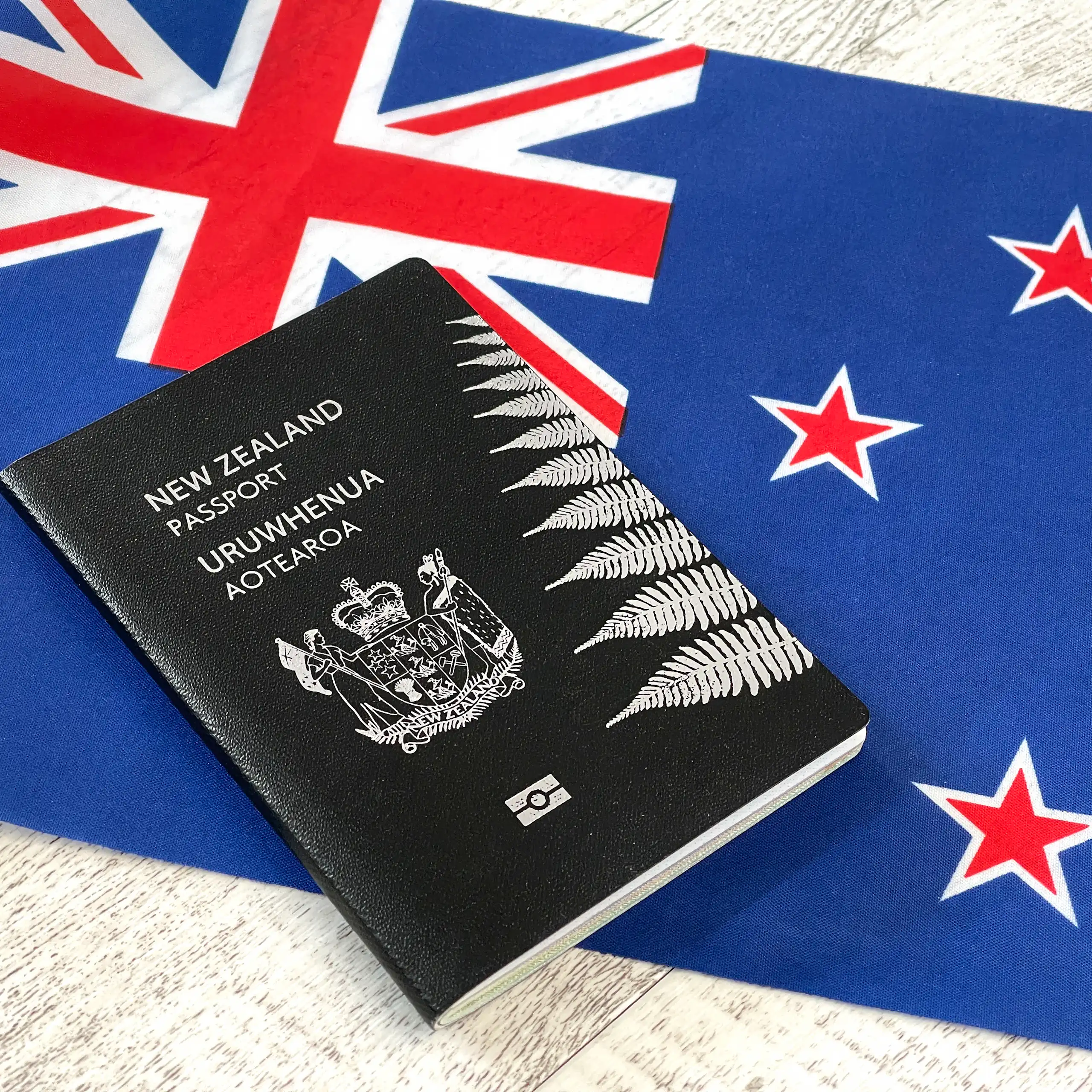 New Zealand passport lying on top of a New Zealand flag